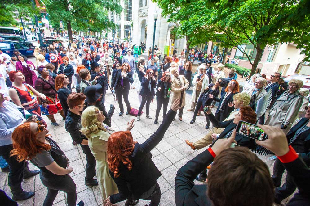 Large group shot of Good Omens costumers taking selfies.